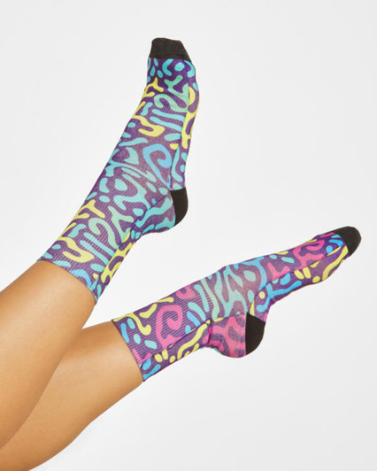 Colourful patterned socks featuring blue, yellow, and pink designs with black accents and a logo.
