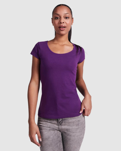A purple t-shirt with short sleeves and a scoop neckline, modelled by a woman. It has a simple design and a fitted style.