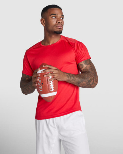 A red T-shirt displayed on a model holding a football, featuring short sleeves and a sleek fit.