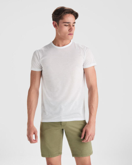 A white T-shirt worn by a young man, paired with khaki shorts, featuring a simple design and a logo.