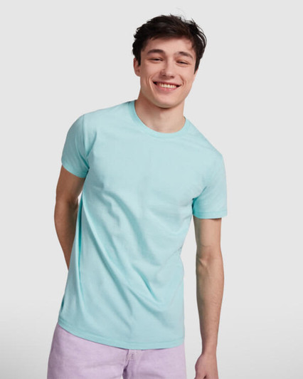 A light blue T-shirt featuring a classic crew neckline, displayed by a smiling young man. The shirt has a logo.