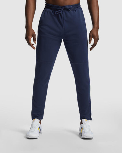 Navy track pants with a drawstring waist, featuring a logo on the side, styled with white sneakers.