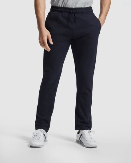 Track pants in navy blue, featuring a casual fit and an elastic waistband, worn with a grey top and white shoes.