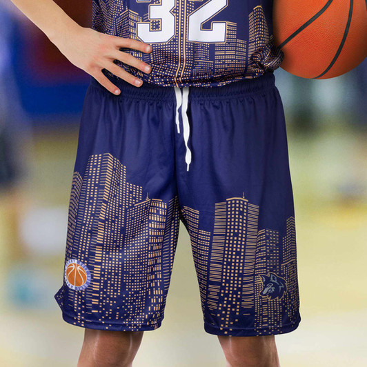 Navy basketball shorts featuring a city skyline design and a logo, paired with a basketball.