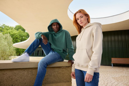 A khaki oversized hoody on a person and a green oversized hoody on another person, both in an outdoor setting.