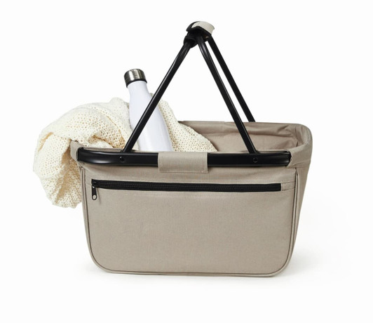 A beige shopper bag with a black handle, featuring a drink bottle and a soft blanket inside.