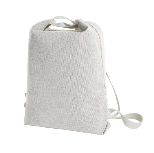 A light grey bag with a simple design, featuring adjustable straps and a top handle. It has a logo on the side.