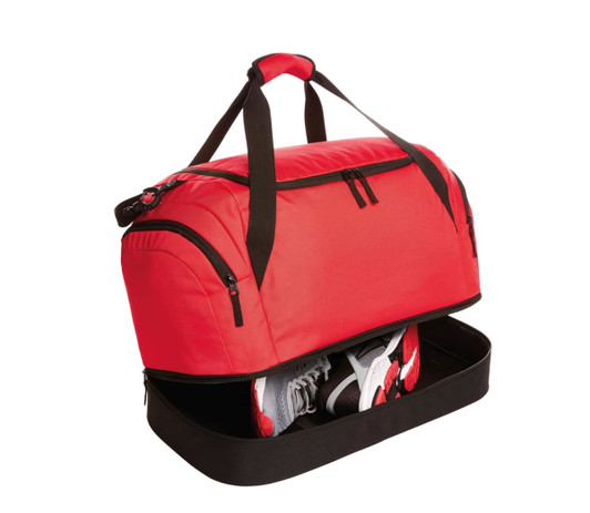 A red duffle bag with black accents featuring a zippered compartment for shoes. It has sturdy handles for easy carrying.