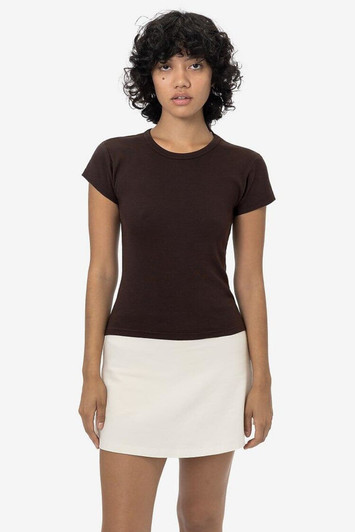 A brown cap sleeve baby tee displayed on a model, paired with a white skirt. The shirt has a subtle logo.