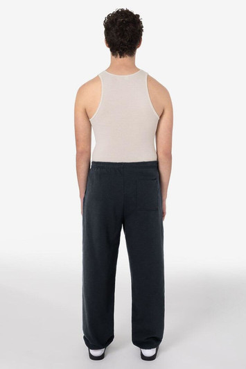 A person wearing dark grey heavy fleece sweatpants and a beige tank top, viewed from the back.