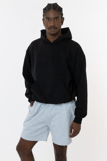 A black Mineral Wash Fleece Wide Hoodie displayed on a model wearing grey shorts. The hoodie features a logo.