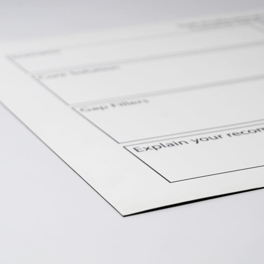 A white magnetic whiteboard with black outline sections for notes, featuring a logo in the corner.