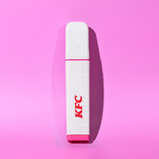 A highlighter in white with a pink cap, featuring a logo on its side, set against a pink background.