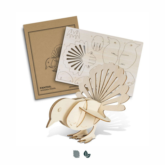 A wooden model of a fantail bird in natural tones, alongside its crafting template packaging.