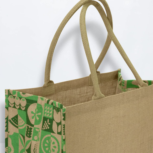 A jute tote bag in natural brown with a vibrant green patterned design and two sturdy handles.