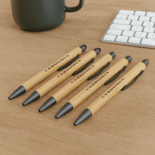 A set of bamboo pens in natural wood and black, featuring a logo, displayed on a wooden surface.