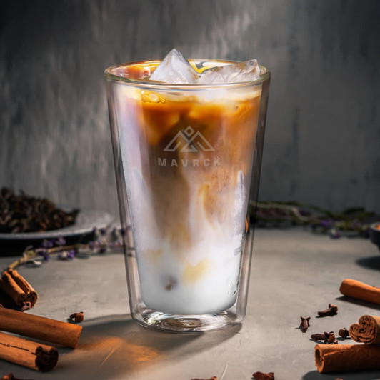 A drink bottle featuring a clear design with iced coffee and milk, surrounded by cinnamon sticks and spices.