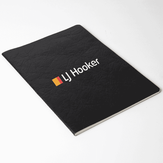 A black Velour DuPont A5 notebook with a textured cover and a logo on the front.