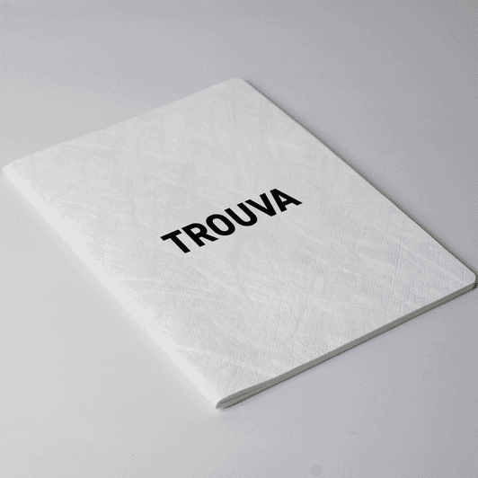 A white A5 notebook with a textured cover and a black logo on the front.