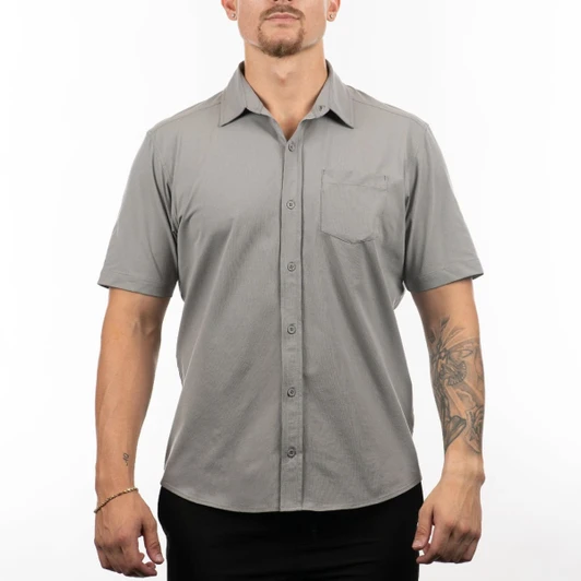 A short sleeve shirt in grey, featuring a button-up front and a chest pocket, displayed on a model.