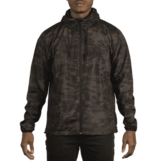 A lightweight windbreaker in a dark camouflage pattern, featuring a hood and zippers, displayed on a model.