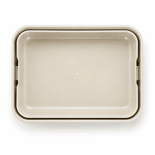 A light beige rectangular lunchbox with a smooth surface and rounded edges. It features a logo.