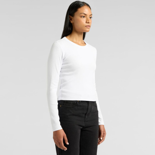A long-sleeve white t-shirt is displayed on a model, paired with black jeans. The shirt has a simple design and a logo.