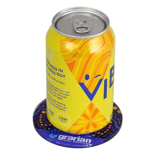 A drink can sits on a round, purple glass coaster featuring a logo, with vibrant yellow and orange designs.