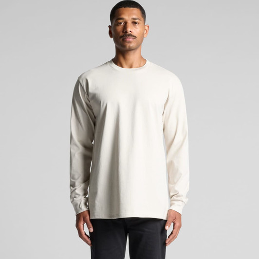 A long-sleeved, cream-coloured t-shirt worn by a man, with a logo visible on the garment.