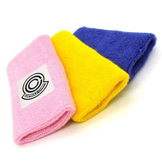 Three folded wristbands in pink, yellow, and blue, featuring a logo on the pink band.