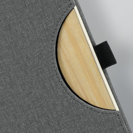 A grey Atoll Notebook featuring a wooden backing, with a curved pocket design and a black elastic strap.