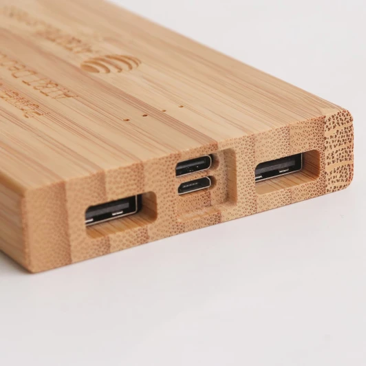 A bamboo power bank with multiple charging ports, featuring a natural wood finish. It includes USB and USB-C connections.