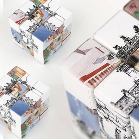 A set of colourful 3x3 puzzle cubes featuring various intricate designs and patterns, with a logo visible.
