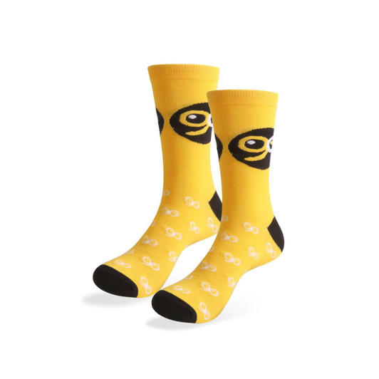 Yellow woven bamboo socks featuring a pattern of black and white designs, with a logo on one side.