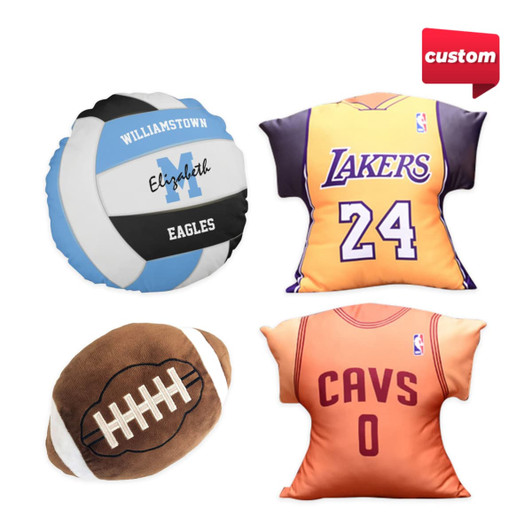 Four custom pillows in various designs: a volleyball, basketball jersey, football, and an NBA-themed pillow, featuring vibrant colours.