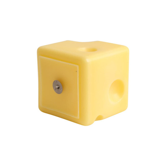 A square yellow candle shaped like cheese, featuring a smooth surface and rounded edges.