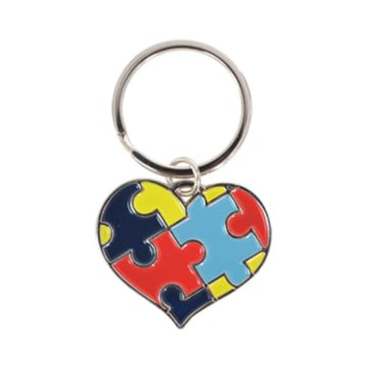 A heart-shaped keyring featuring red, blue, yellow, and black puzzle piece designs, attached to a metal ring.