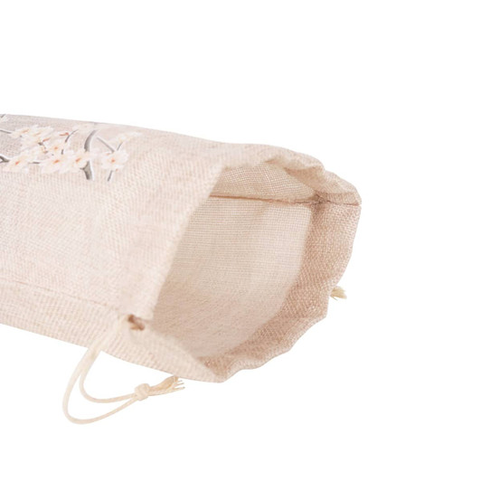 A large jute produce bag in a natural beige colour, featuring embroidered floral designs and drawstring closure.