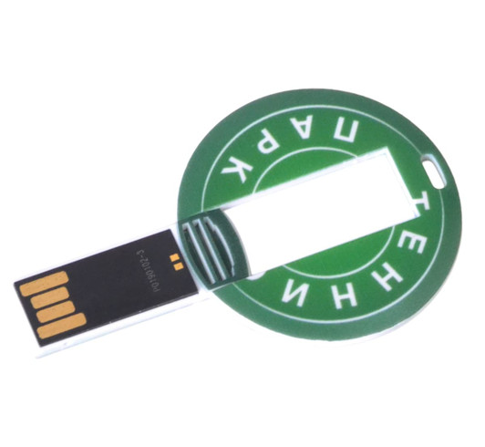 A round, green flash drive with a circular design and a USB connector extending from one side. It features a branding logo.