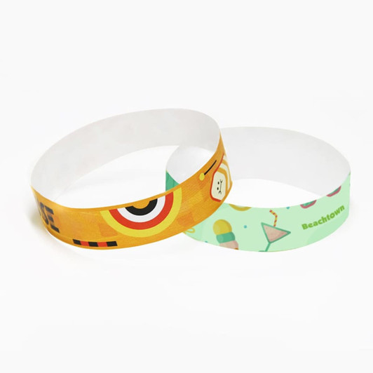 Two disposable Tyvek wristbands featuring vibrant colours and designs, one with a playful motif and the other with a beach theme.