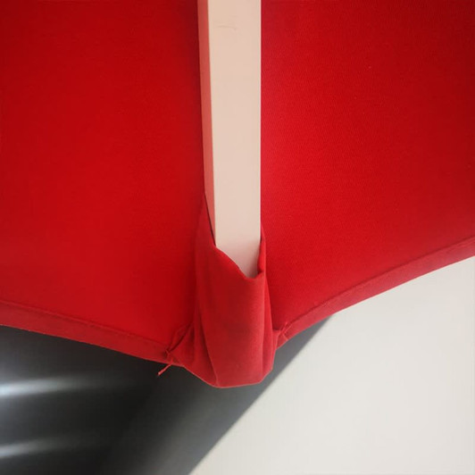 A red square umbrella featuring a white pole and a branded logo detail. Ideal for leisure and outdoor use.