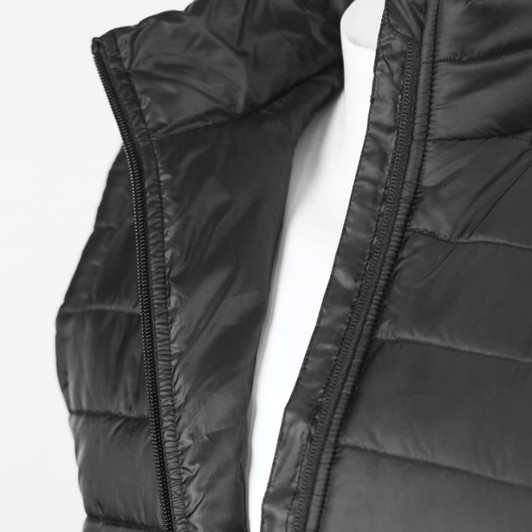 A black women's puffer vest with a zippered opening and quilted texture, displayed on a mannequin.