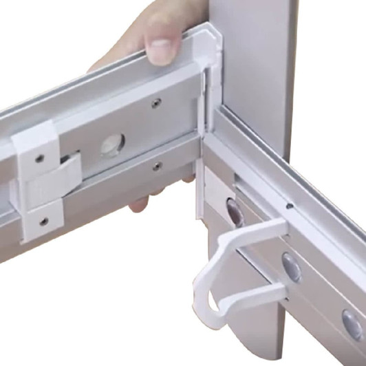 A hand holding a white plastic component of a light box display frame, featuring metal sections and a connection point.