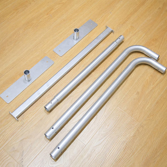 A set of silver metal bars and plates, featuring straight and curved pieces, arranged on a wooden surface.