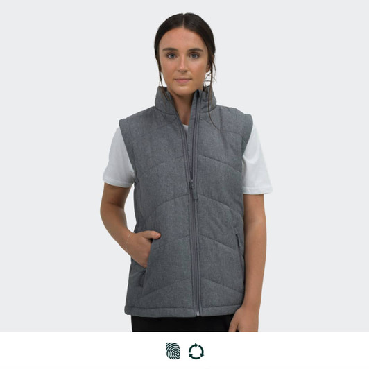 A grey puffer vest with a zip, featuring side pockets, worn by a model on a plain background.