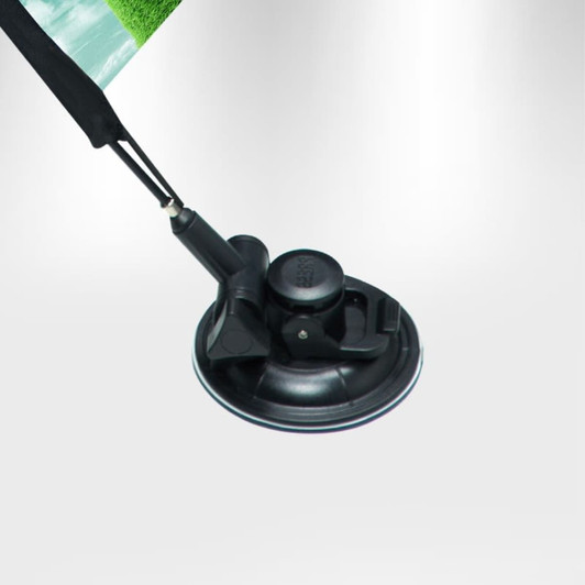 A black suction cup attached to a rectangular flag, featuring a green landscape design.