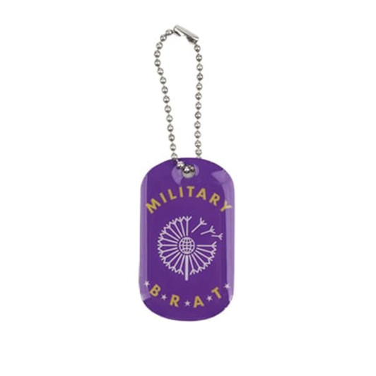 A purple dog tag with a decorative design and a silver chain. It features a logo and the text "MILITARY BRAT".