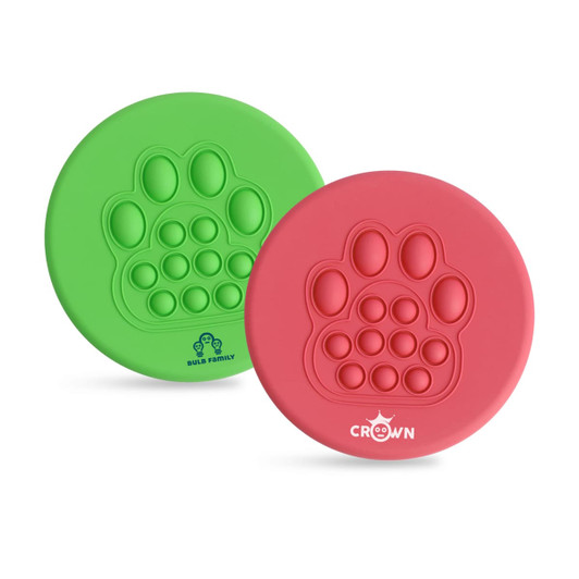 A Pop fidget frisbee set in green and pink, featuring a paw print design with several popping bubbles. Each frisbee has a logo.
