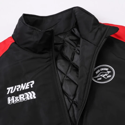 A black puffer gilet with red accents and a logo, featuring a quilted interior and high collar.