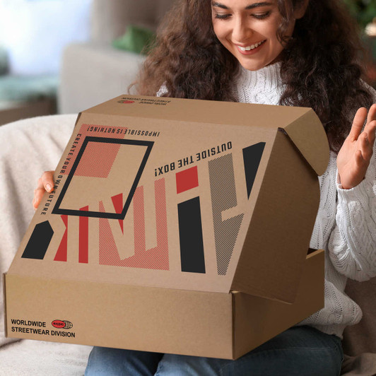 A woman holding a large brown die cut box with a locking lid, featuring a logo and bold graphic design.